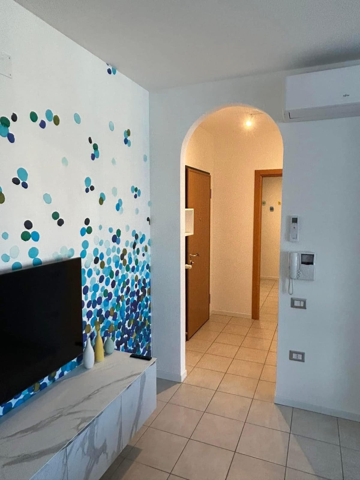 Passaggio ad arco verso l'ingresso, accanto alla parete con il murale
