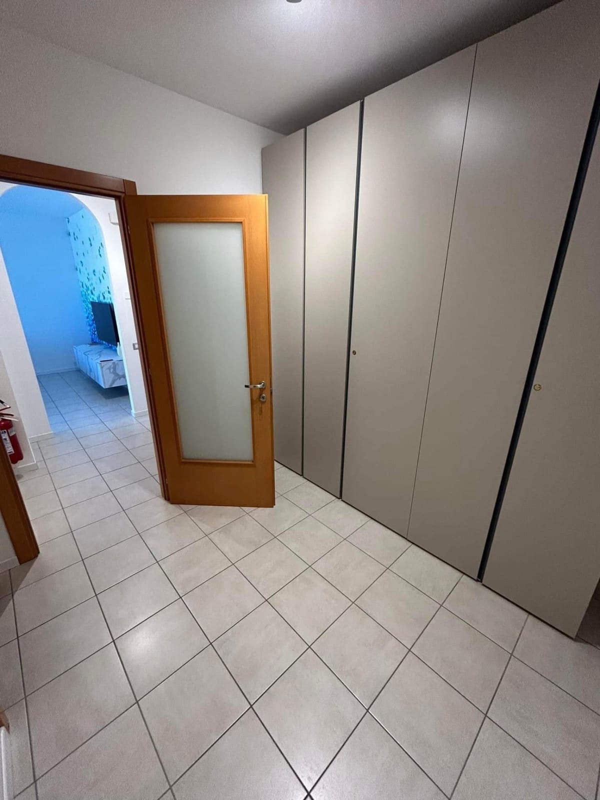 Corridoio con ampio armadio a muro e porta verso il soggiorno